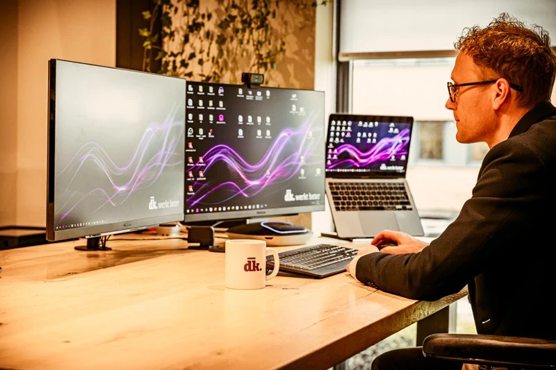 Een medewerker van DKSoftware aan het werk achter zijn bureau